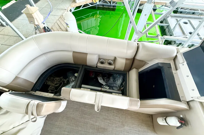 Slide: The Image of 2017 Bentley Pontoons 223 Elite Cruise with open storage compartments on a dock. - 25