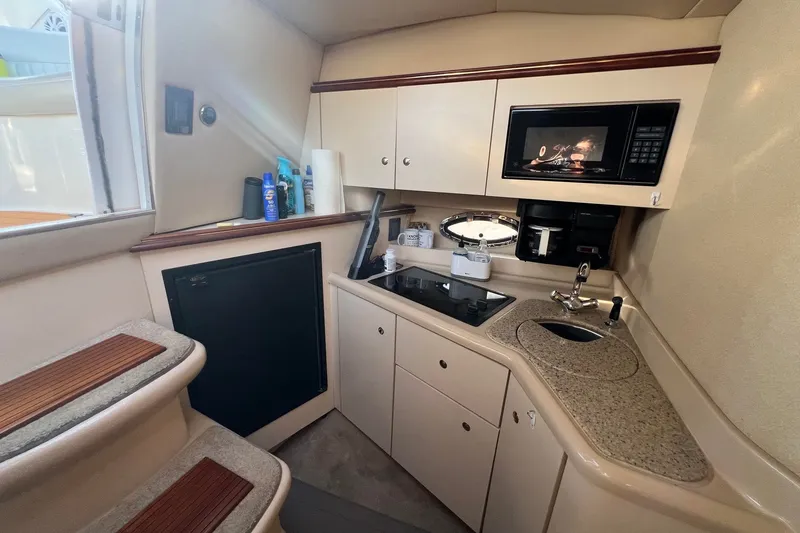 Slide: The Image of 2003 Cruisers Yachts 3372 Express interior kitchen with microwave, sink, and stove. - 5