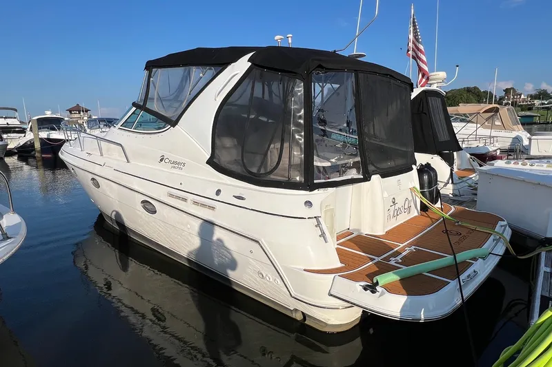 Slide: The Image of 2003 Cruisers Yachts 3372 Express docked at marina, featuring sleek design and American flag. - 1