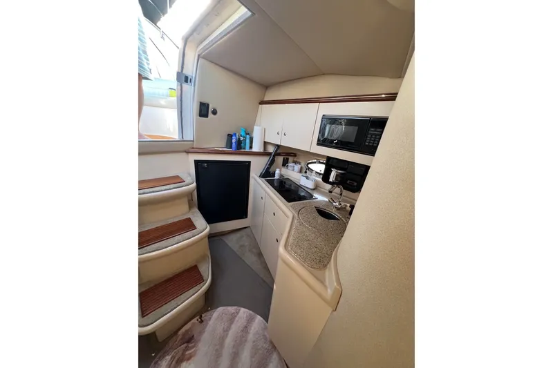 Slide: The Image of Interior of 2003 Cruisers Yachts 3372 Express, featuring a compact kitchen area. - 45