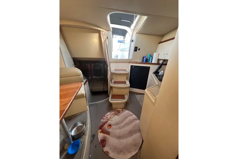 Slide: The Image of Interior of 2003 Cruisers Yachts 3372 Express, featuring compact kitchen and cozy seating area. - 33