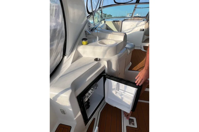 Slide: The Image of 2003 Cruisers Yachts 3372 Express interior with open mini fridge and sink area. - 51