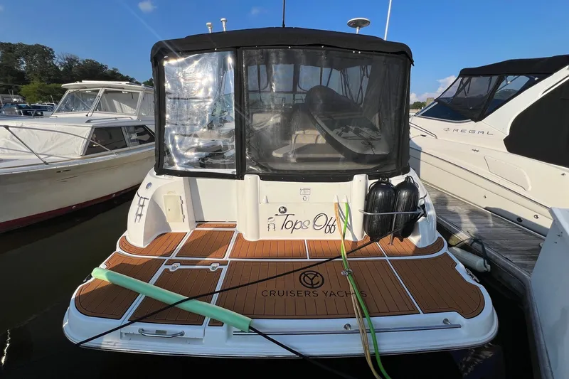 Slide: The Image of 2003 Cruisers Yachts 3372 Express docked, featuring teak deck and protective canopy. - 4