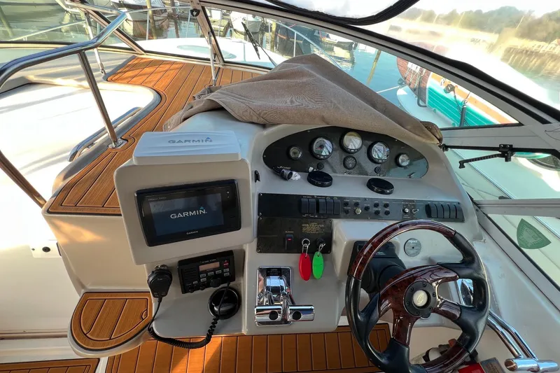 Slide: The Image of 2003 Cruisers Yachts 3372 Express helm with Garmin navigation system and wooden steering wheel. - 2
