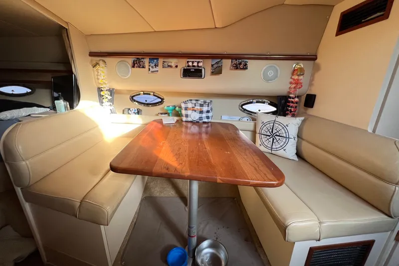 Slide: The Image of Interior of 2003 Cruisers Yachts 3372 Express with cozy seating and wooden table. - 44