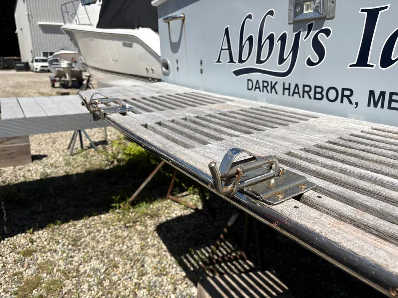 Slide: The Image of The image shows the stern of a boat with a wooden swim platform and metal fittings. - 28