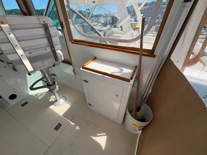 Slide: The Image of The image shows a boat cockpit with a white seat and a small cabinet. - 18
