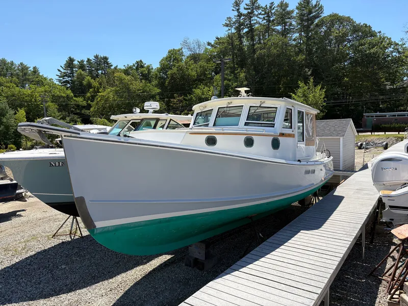The Image of A 1988 Jarvis Newman 32 boat on dry dock. It features a white hull and green bottom. - 1