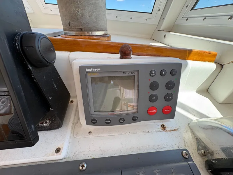 Slide: The Image of The image shows a Raytheon autopilot system on a boat, surrounded by windows and wood trim. - 15