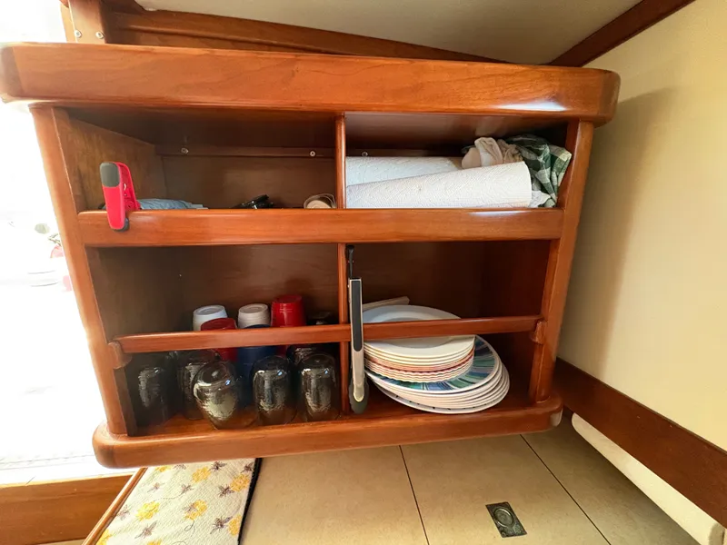 Slide: The Image of A wooden shelf in a boat holding dishes, cups, and kitchen items. - 20
