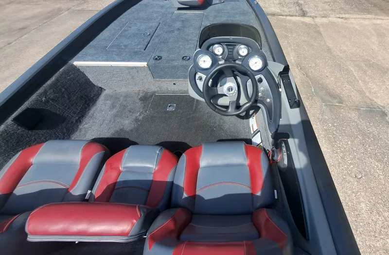 Slide: The Image of The image shows the cockpit of a 2014 Tracker Pro Team 190 boat with gray and red seats. - 18