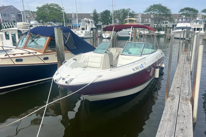 Slide: The Image of 2006 Monterey 248LS Montura Bowrider docked in a marina, surrounded by other boats. - 5