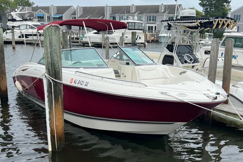 Slide: The Image of 2006 Monterey 248LS Montura Bowrider docked in a marina, featuring a red and white exterior. - 4