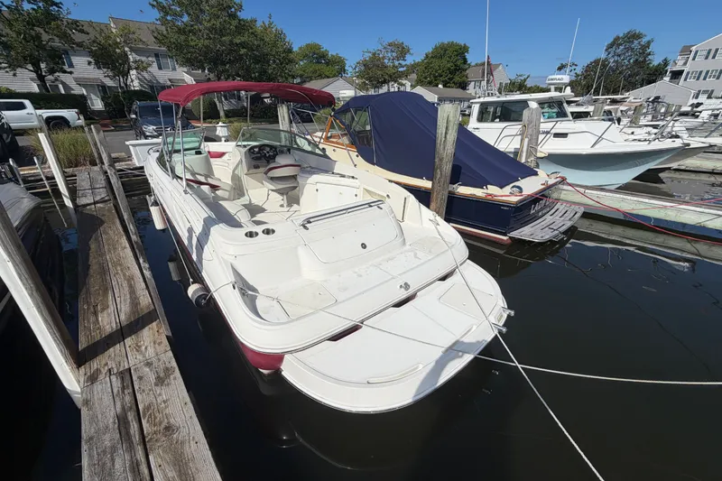Slide: The Image of 2006 Monterey 248LS Montura Bowrider docked at marina, featuring spacious seating and canopy. - 16