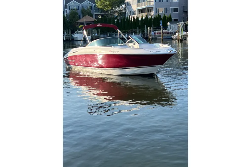 Slide: The Image of 2006 Monterey 248LS Montura Bowrider in calm waters near a marina. - 3