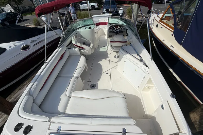 Slide: The Image of 2006 Monterey 248LS Montura Bowrider with white seating and red canopy, docked at marina. - 18