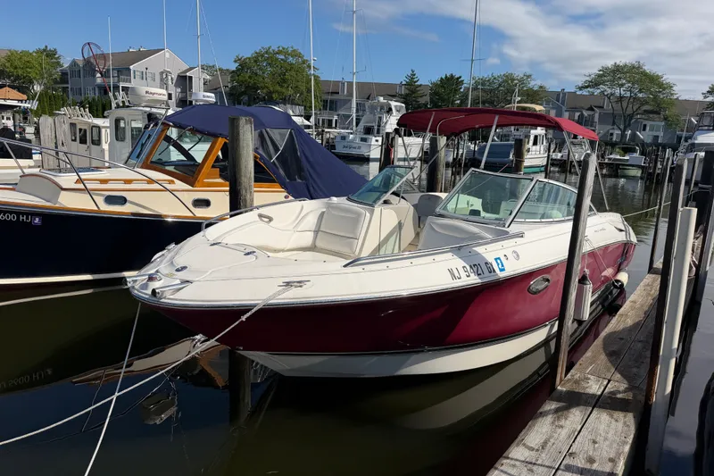 Slide: The Image of 2006 Monterey 248LS Montura Bowrider docked at a marina, featuring a red and white design. - 12