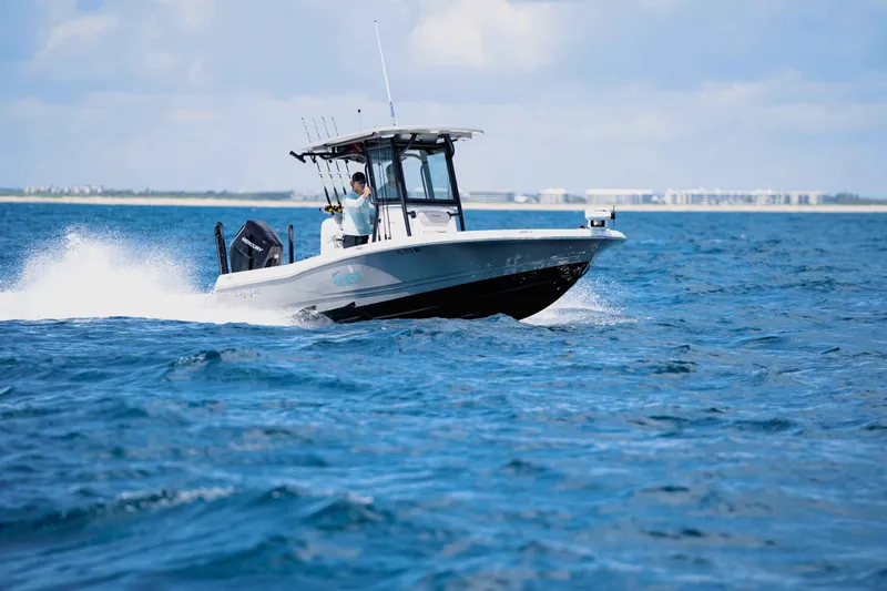 The Image of A 2027 Caymas 26 HB boat speeds across the open sea under sunny skies. - 1