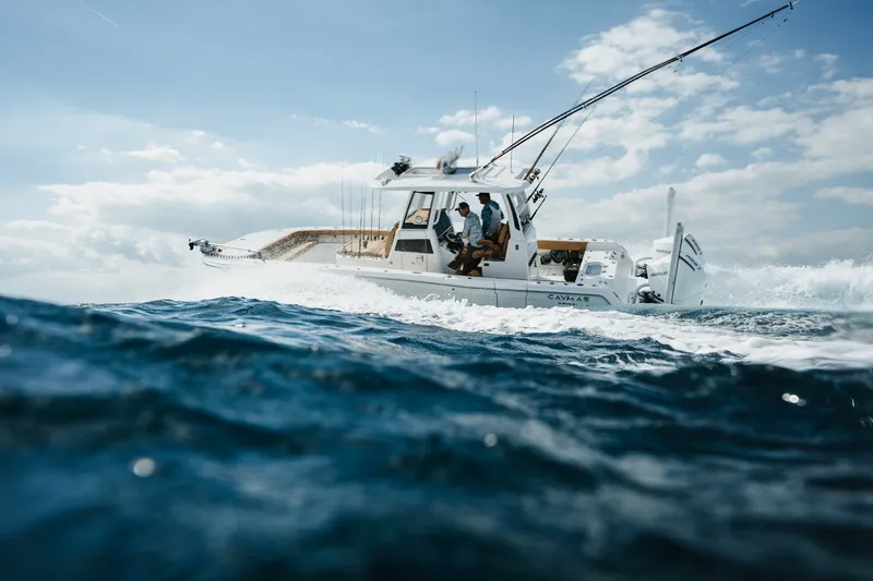 The Image of A Caymas 29 CT boat navigates through choppy waters under a cloudy sky. - 1