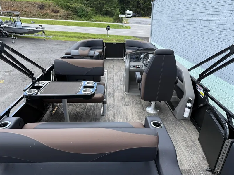 Slide: The Image of The image shows the interior of an Avalon 2585 LSZ Entertainer pontoon boat with sleek seating and a table. - 14