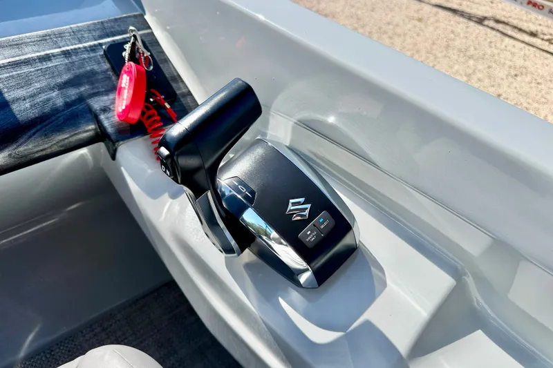 Slide: The Image of Throttle control of a 2027 Vanderbilt 23QS boat with key and safety lanyard. - 15