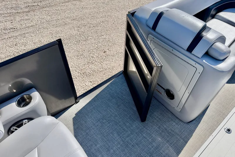 Slide: The Image of 2027 Vanderbilt 23QS boat interior with open storage compartment and cup holders. - 26
