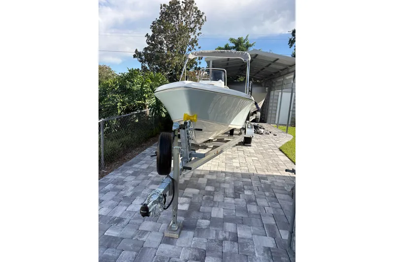 Slide: The Image of 2027 Key West 179 FS boat on trailer in driveway, under a canopy. - 17