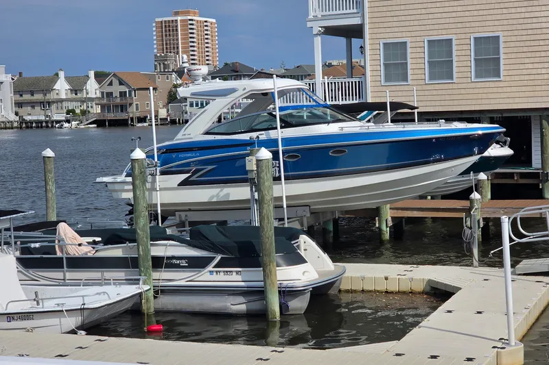 Slide: The Image of 2020 Formula 330 Crossover Bowrider I/O docked in a marina, surrounded by buildings. - 3