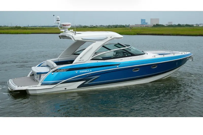 The Image of 2020 Formula 330 Crossover Bowrider I/O in blue, cruising on calm water. - 0