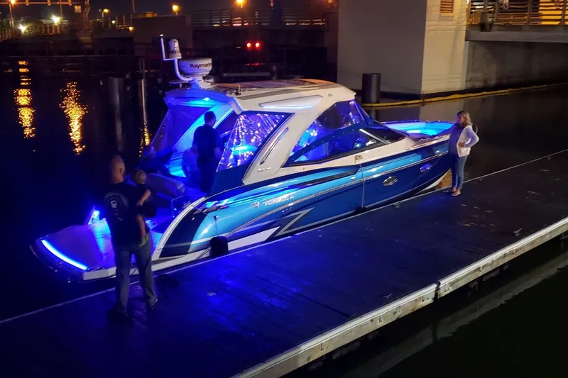 Slide: The Image of 2020 Formula 330 Crossover Bowrider I/O with blue LED lights docked at night. - 4