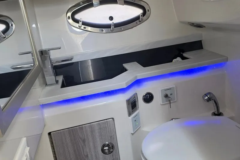 Slide: The Image of 2020 Formula 330 Crossover Bowrider I/O bathroom with modern fixtures and blue LED lighting. - 15