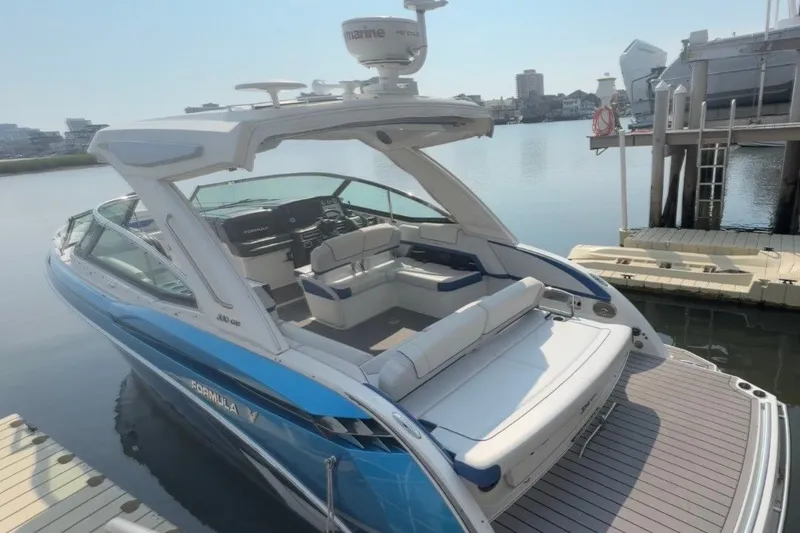 Slide: The Image of 2020 Formula 330 Crossover Bowrider I/O docked, showcasing sleek design and spacious seating. - 2
