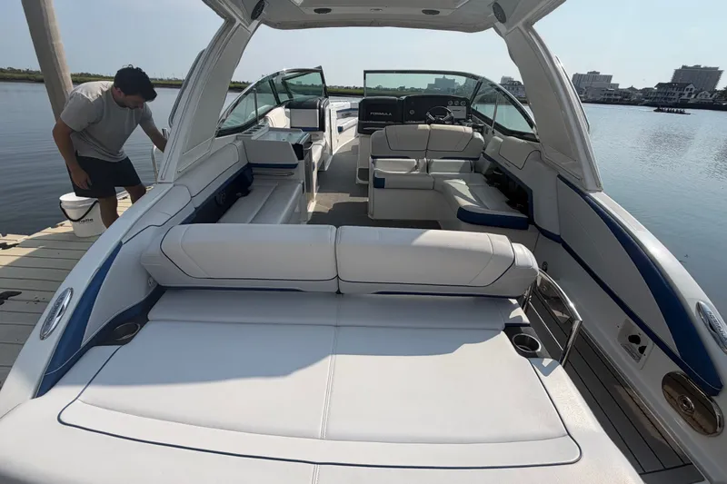 Slide: The Image of 2020 Formula 330 Crossover Bowrider I/O with spacious seating and modern design on a calm lake. - 6