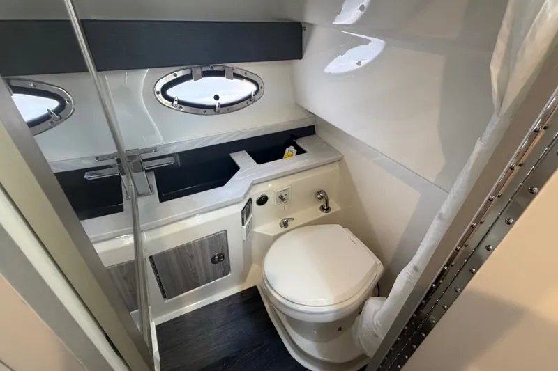 Slide: The Image of 2020 Formula 330 Crossover Bowrider I/O bathroom with modern fixtures and porthole windows. - 14