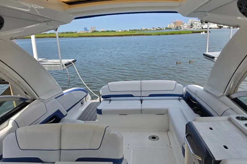 Slide: The Image of 2020 Formula 330 Crossover Bowrider I/O interior with spacious seating, overlooking serene waterfront. - 8
