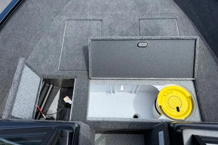 Slide: The Image of 2026 Crestliner 1650 Kodiak WT boat storage compartments with open hatch and yellow container. - 5