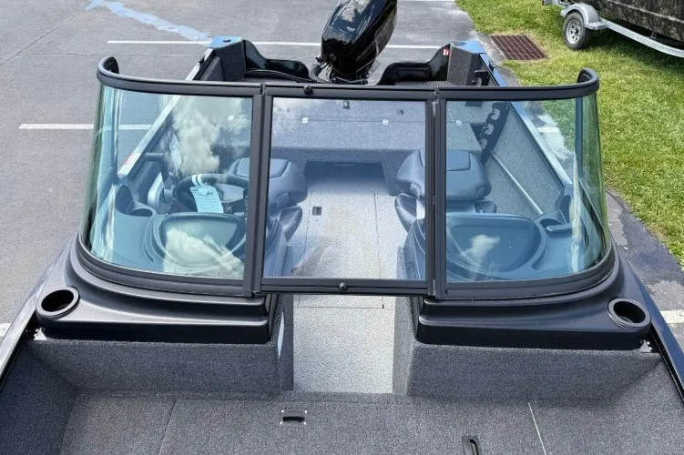 Slide: The Image of 2026 Crestliner 1650 Kodiak WT boat interior with windshield and seating, parked on pavement. - 7