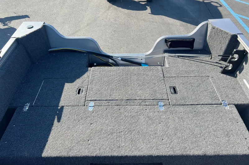 Slide: The Image of Interior view of 2026 Crestliner 1650 Kodiak WT boat, featuring carpeted storage compartments. - 16