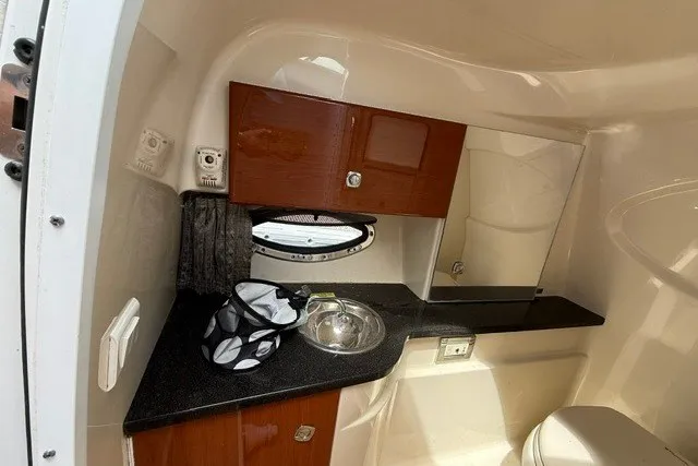 Slide: The Image of Interior of 2011 Formula 310 FX5 Bowrider boat, featuring a compact bathroom with sink and storage. - 17