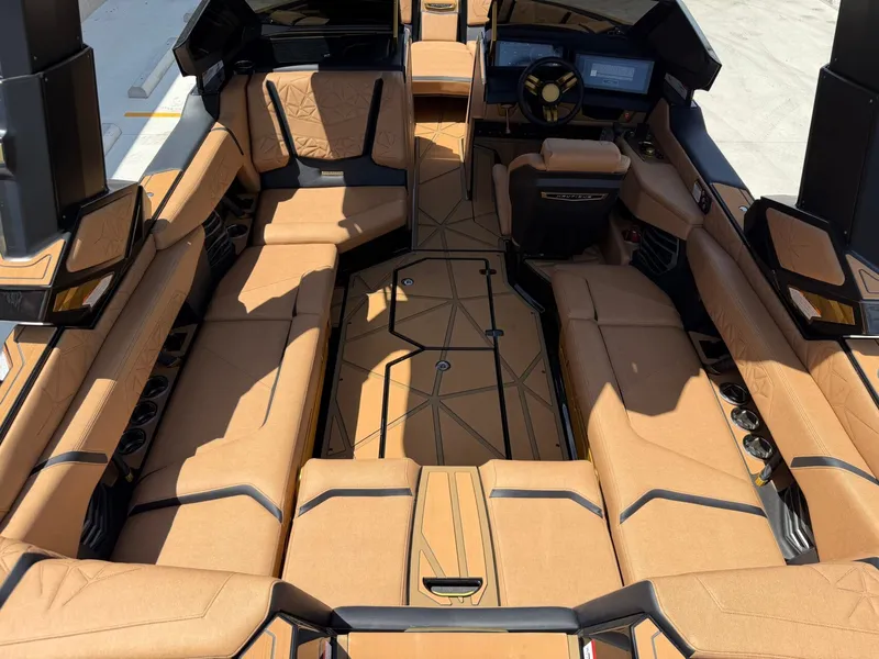 Slide: The Image of The image shows the interior of a 2027 Nautique Super Air Nautique G23 Paragon with luxurious brown upholstery and a modern cockpit. - 17