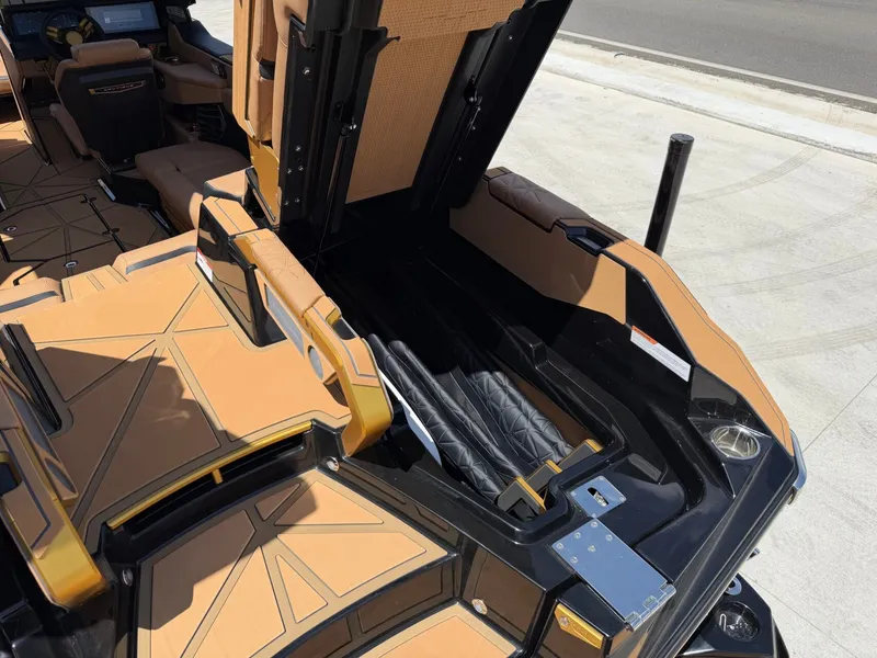 Slide: The Image of The image shows the interior of a 2027 Nautique Super Air Nautique G23 Paragon with open storage compartments. - 13