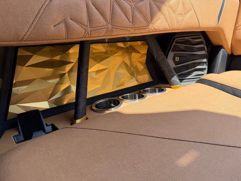 Slide: The Image of Close-up of a Nautique Super Air Nautique G23 Paragon interior with gold accents and cup holders. - 22