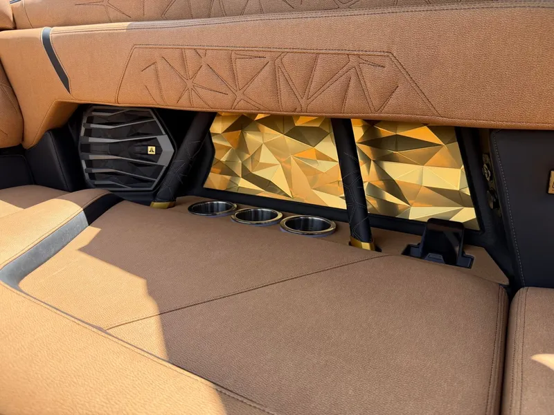 Slide: The Image of Luxurious interior with geometric patterns, speaker, and cup holders in the Nautique Super Air Nautique G23 Paragon. - 23