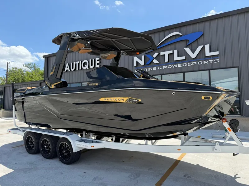 Slide: The Image of A sleek black boat on a trailer in front of a building with "NXT LVL" signage. - 2