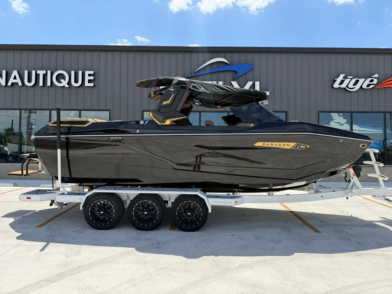 Slide: The Image of A sleek black boat on a trailer in front of a building, featuring gold accents. - 4