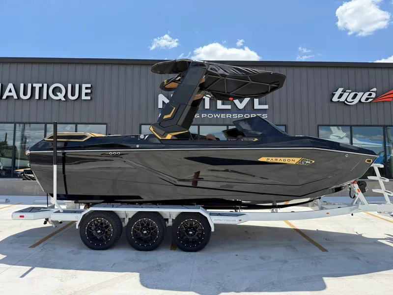 The Image of A sleek black boat on a trailer in front of a building. It features a modern design. - 1