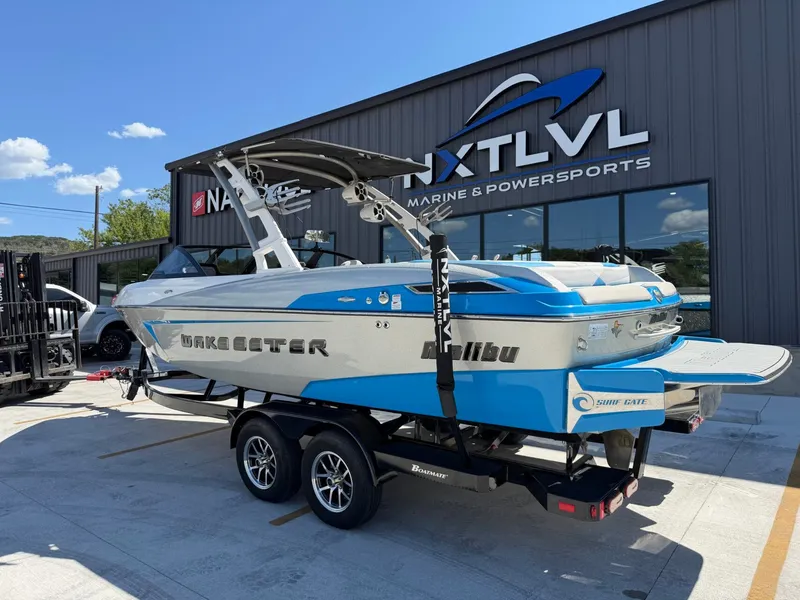 Slide: The Image of A blue and white 2016 Malibu Wakesetter 23 LSV on a trailer in front of a building. - 3
