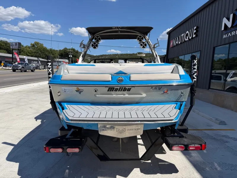 Slide: The Image of A blue 2016 Malibu Wakesetter 23 LSV is parked, showing the boat's hull and rear features. - 4