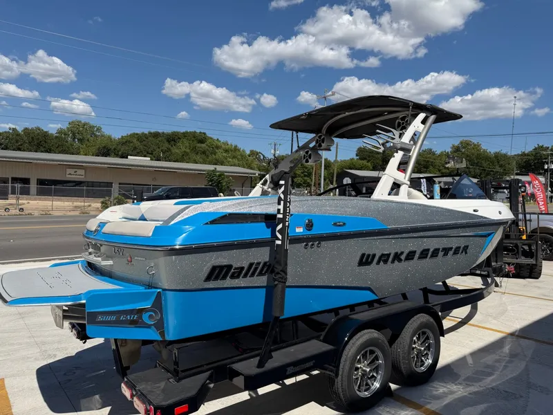 Slide: The Image of A blue 2016 Malibu Wakesetter 23 LSV on a trailer under a sunny sky. - 5