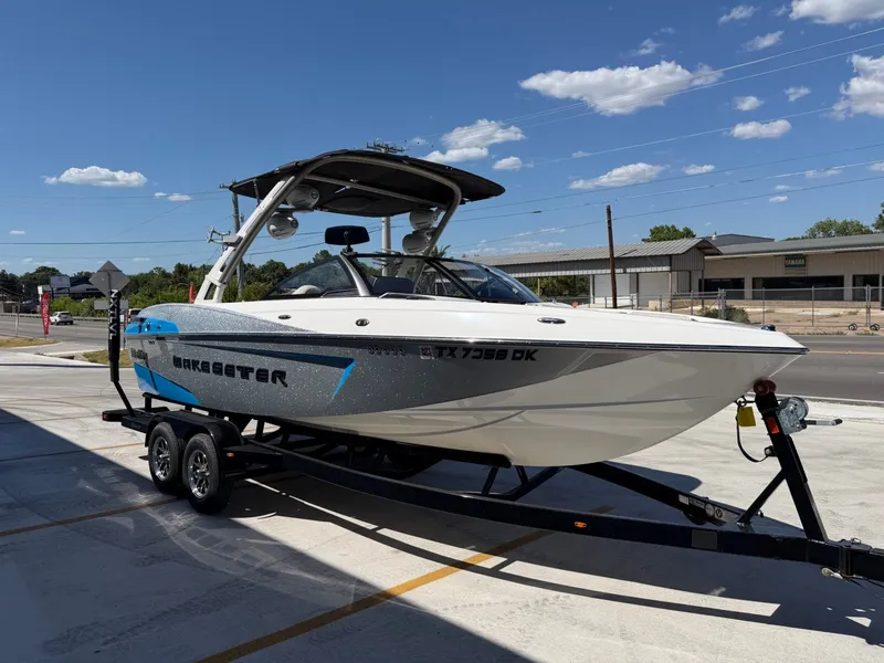 Slide: The Image of A white 2016 Malibu Wakesetter 23 LSV boat on a trailer in a parking lot. - 7